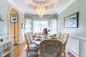 A dining room with a chandelier, a table set for six, and chairs with floral upholstery. - Mableton 4BR - Near Truist Park & Six Flags (Mableton)