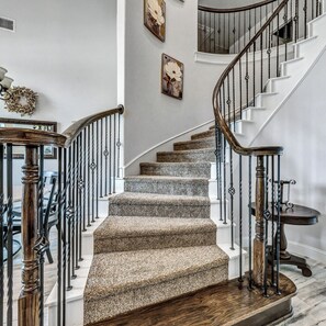 Una escalera en espiral con peldaños alfombrados y barandillas de metal.