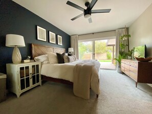 A bedroom with a bed, nightstands, a ceiling fan, a dresser, and a view of the outdoors. - Spacious Tempe Retreat - Patio - Dog Friendly - Near ASU & Airport - Grand Piano (Tempe)