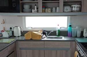 A kitchen with a window, a sink, and various kitchen appliances.