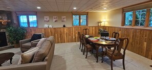 Zona pranzo con tavolo in legno, sedie e camino.