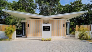 A modern building with a sign reading 'Tsuru Villas.' - Villas Tsuru (Hone Creek)