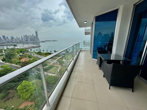Ein Balkon mit Blick auf eine Stadtlandschaft und ein Gewässer.