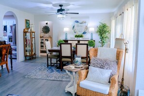 A dining area with a chandelier, a dining table, chairs, and a decorative wall piece. - Nanny`s Nest - A Gentle Place to Land (Nederland)