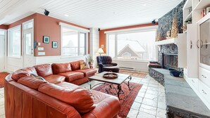 Una sala de estar con un sofá de cuero, una mesita de centro y una chimenea de piedra.