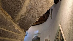 Eine Treppe mit Steinwänden und einer Decke mit freiliegenden Balken.
