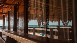 Una estructura de madera con amplios ventanales con vistas a la playa.