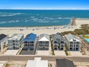 A beachfront property with multiple buildings, a sandy beach, and the ocean. - Sea Dreams- Ocean Isle Beach (Ocean Isle Beach)
