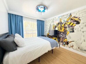 Ein Schlafzimmer mit Bett, Schreibtisch und Wandbild.