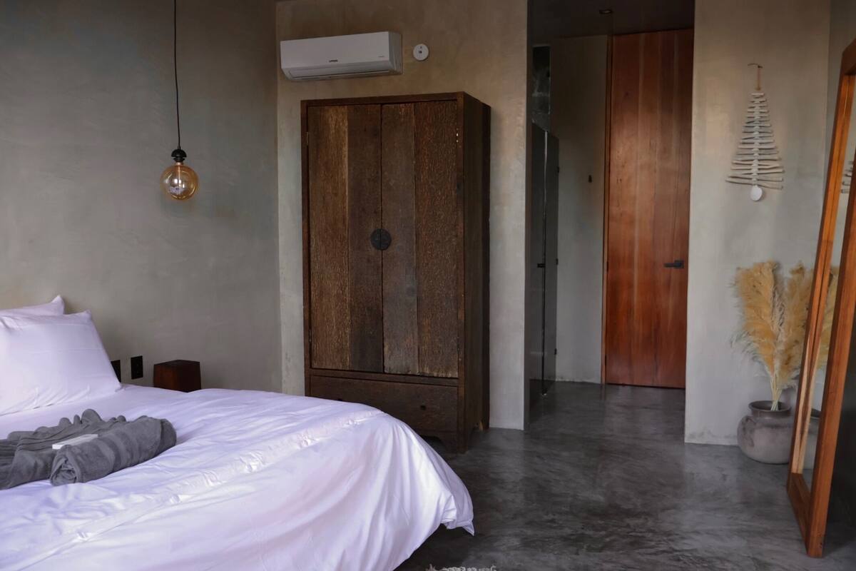 Un dormitorio con cama, armario, aire acondicionado y un adorno en la pared.