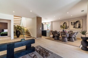 A modern interior with a staircase, dining area, and living space. - Villa Maya · Rooftop beach access heated pool (Agde)