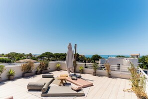 A rooftop terrace with outdoor seating, potted plants, and a view of the sea. - Villa Maya · Rooftop beach access heated pool (Agde)