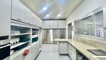 Una cucina moderna con elettrodomestici in acciaio inossidabile, mobili bianchi e un'ampia finestra.