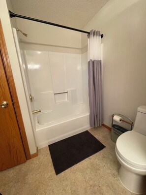 Ein Badezimmer mit Badewanne, Toilette und Duschvorhang.
