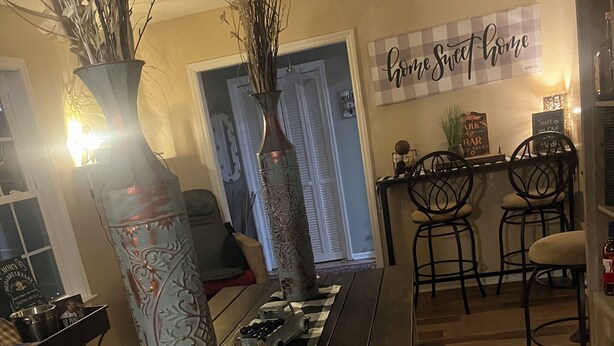 A dining area with a long wooden table, two decorative vases, and a checkered table runner. - 3/2 house in Statesboro with nearby GA Southern and Savannah (Statesboro)