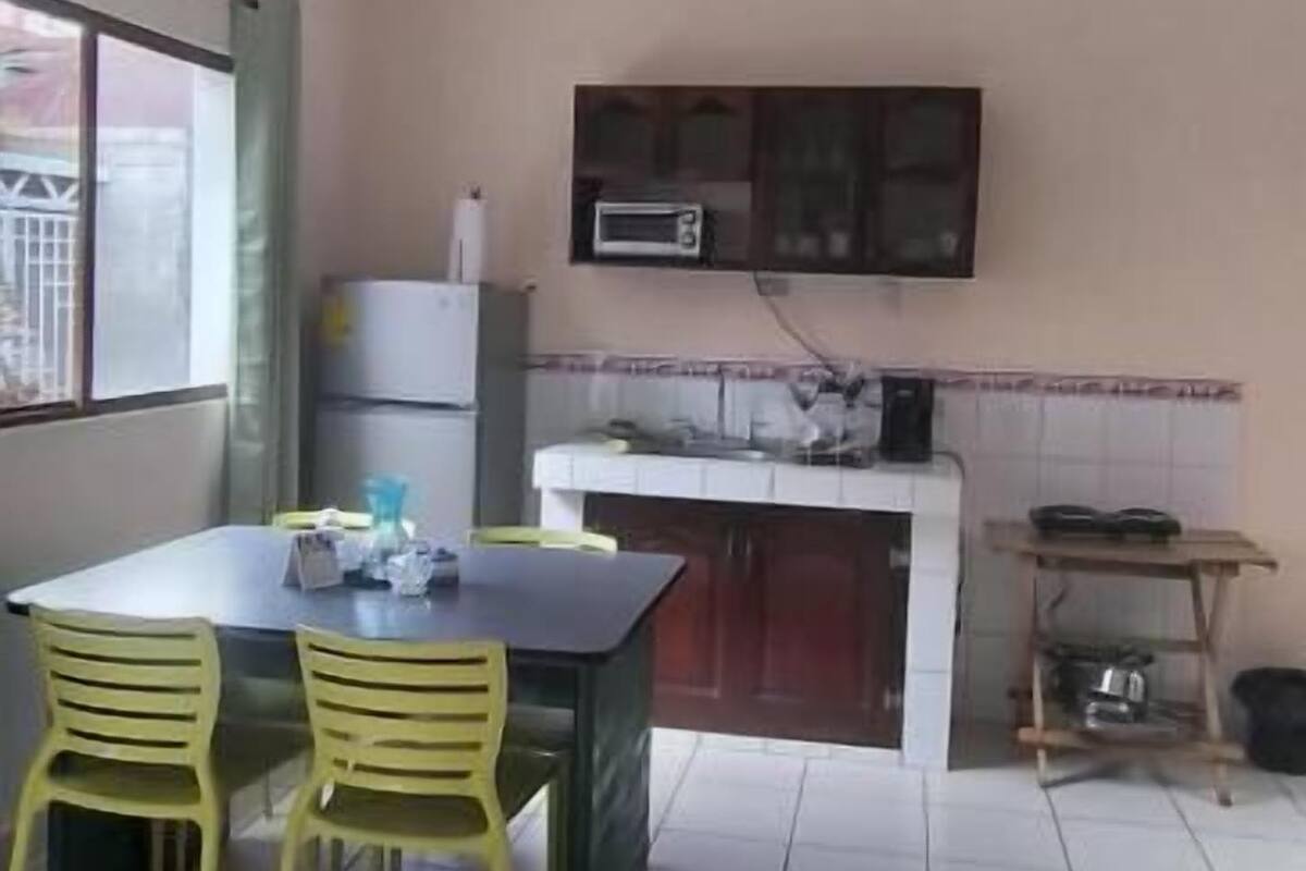 A kitchen with a dining table and chairs, a microwave, and cabinets.