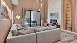 Ein modernes Wohnzimmer mit einem Ecksofa, einem Fernseher und einem Kamin.