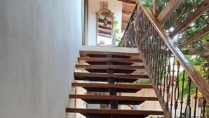 Una escalera de madera con barandilla de metal que conduce a un nivel superior.