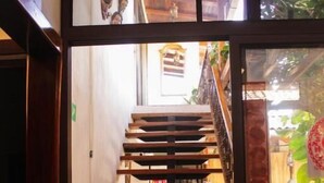Una escalera de madera que sube a un piso superior, con vista al espacio interior.