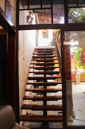 A wooden staircase leading to an upper floor, with a view of the interior space below.
