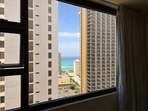Blick durch ein Fenster auf hohe Gebäude und ein Gewässer.