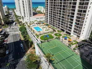 Ein Hochhaus-Hotel mit Pool auf dem Dach, Tennisplatz und Blick aufs Meer.