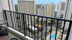 Ein Balkon mit Blick auf einen Swimmingpool und umliegende Gebäude.