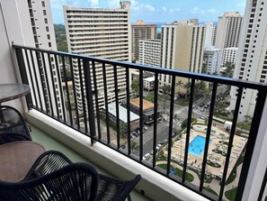 Ein Balkon mit Blick auf einen Swimmingpool und umliegende Gebäude.