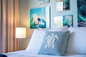 A hotel room with a bed, a lamp, and artwork on the wall. - Ocean View Studio, Newly Renovated, Free Parking (Honolulu)