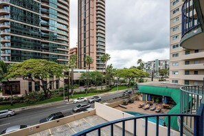A high-rise building with a pool area, multiple floors, and a view of the street. - Central Waikiki 2 Bedroom, AC, Lanai, Pool, King (Honolulu)