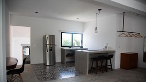 Una cocina moderna con una isla grande, un refrigerador y un ventanal que proporciona luz natural.