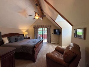 A bedroom with a bed, a chair, a ceiling fan, a TV, and a window with curtains. - Ember Creek 3 Bedroom & Loft, Family Retreat! (Shaver Lake)