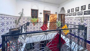 A room with a high ceiling, patterned walls, a staircase, and a skylight. - Stay in the Heart of Marrakech Medina – Private Room, AC & Rooftop Terrace (Marrakech)