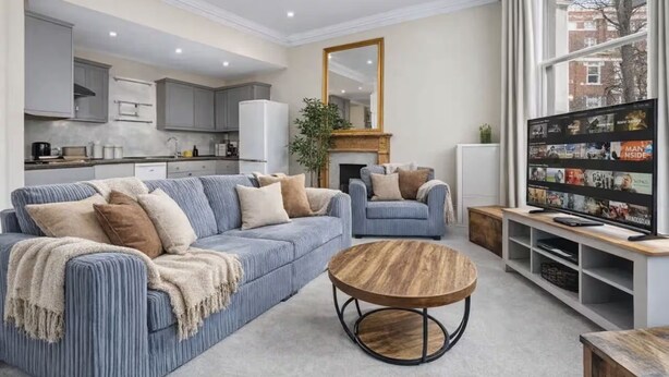 Ein modernes Wohnzimmer mit einer Couch, einem Couchtisch und einem Fernseher.