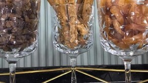 Tres jarrones de vidrio con distintos alimentos sobre una superficie negra.