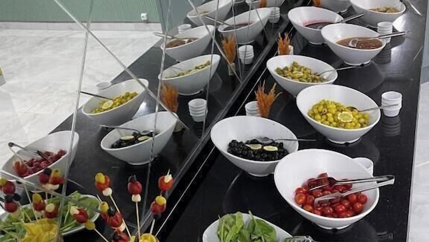 Una mesa de buffet con diversos alimentos y utensilios.