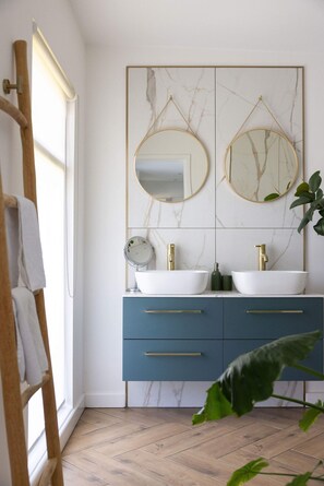 A bathroom with a double sink, two mirrors, a clock, and a plant. - Scandi-style Birdham Retreat With Hot Tub Garden (Chichester)