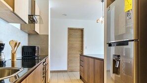 Una cocina moderna con electrodomésticos de acero inoxidable, gabinetes de madera y un horno empotrado.