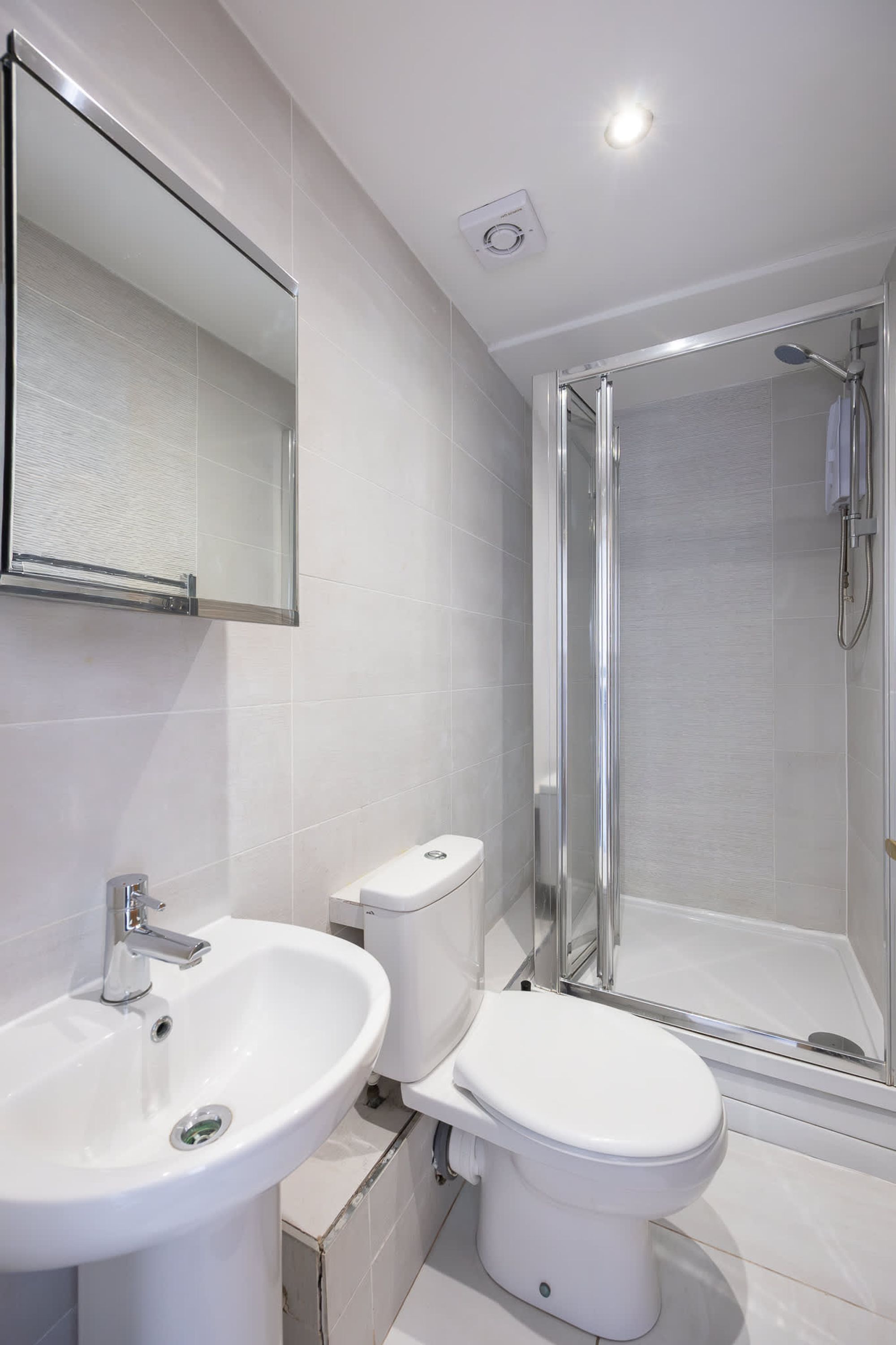 A modern bathroom with a sink, toilet, and glass-enclosed shower.