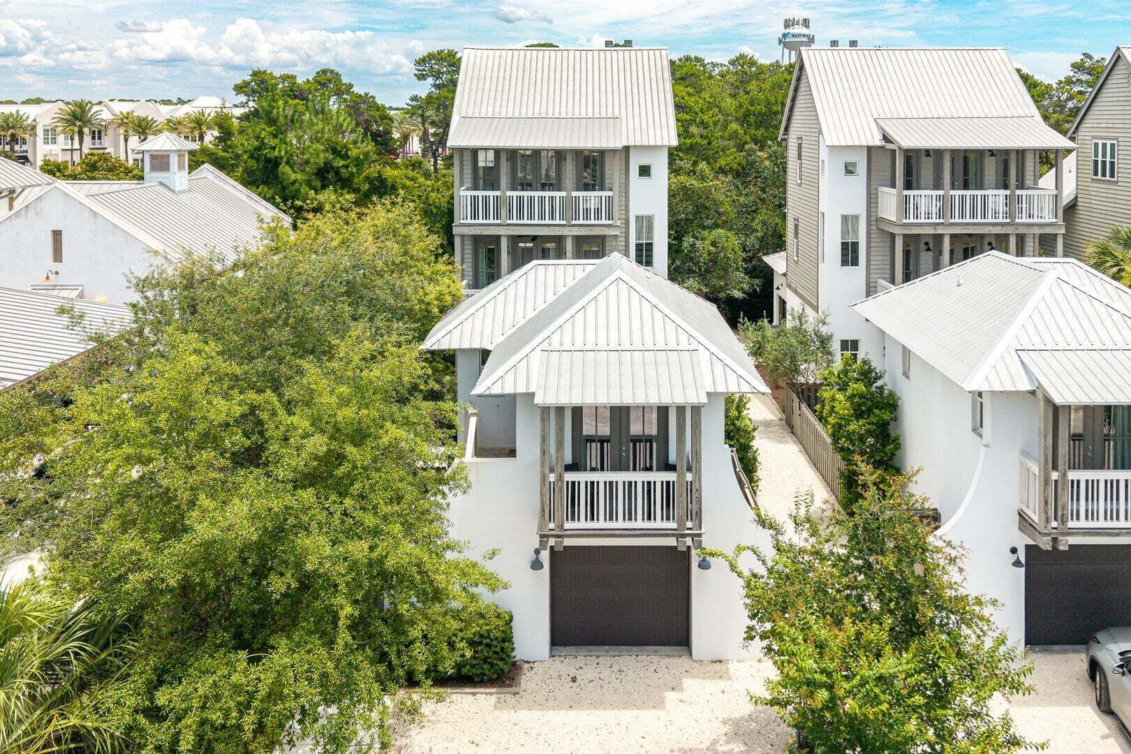 A coastal residential area with white houses featuring balconies and a clear view of the ocean.