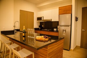 A modern kitchen with a central island, stainless steel appliances, and wooden cabinetry. - Iconic Cerro Views Retreat with Rooftop Pool (Monterrey)