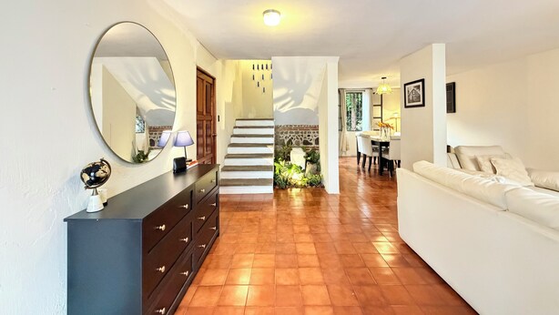 A spacious living area with a staircase, a dining area, and a white sofa. - Casa Fernando in Antigua Guatemala (Antigua Guatemala)