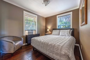 A bedroom with a bed, a chair, a dresser, and two windows with blinds. - Easy Stay - Hot Tub, Elegant, Peaceful! Pet Friendly! (Hood River)