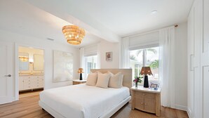 Un'ampia camera da letto con un letto grande, un comodino con una lampada e vista all'esterno attraverso una finestra.