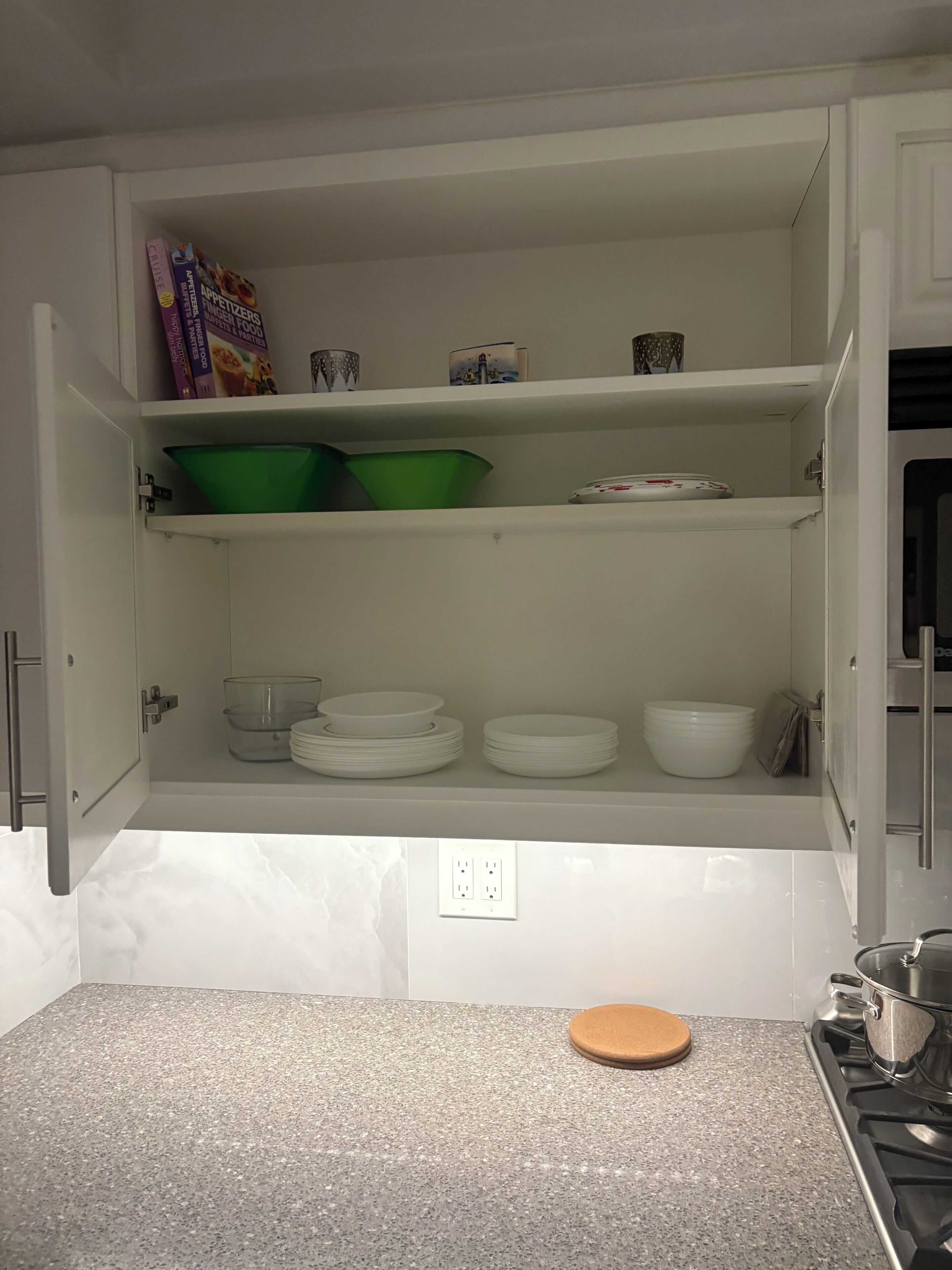 A kitchen with white cabinets, a granite countertop, and a stove.