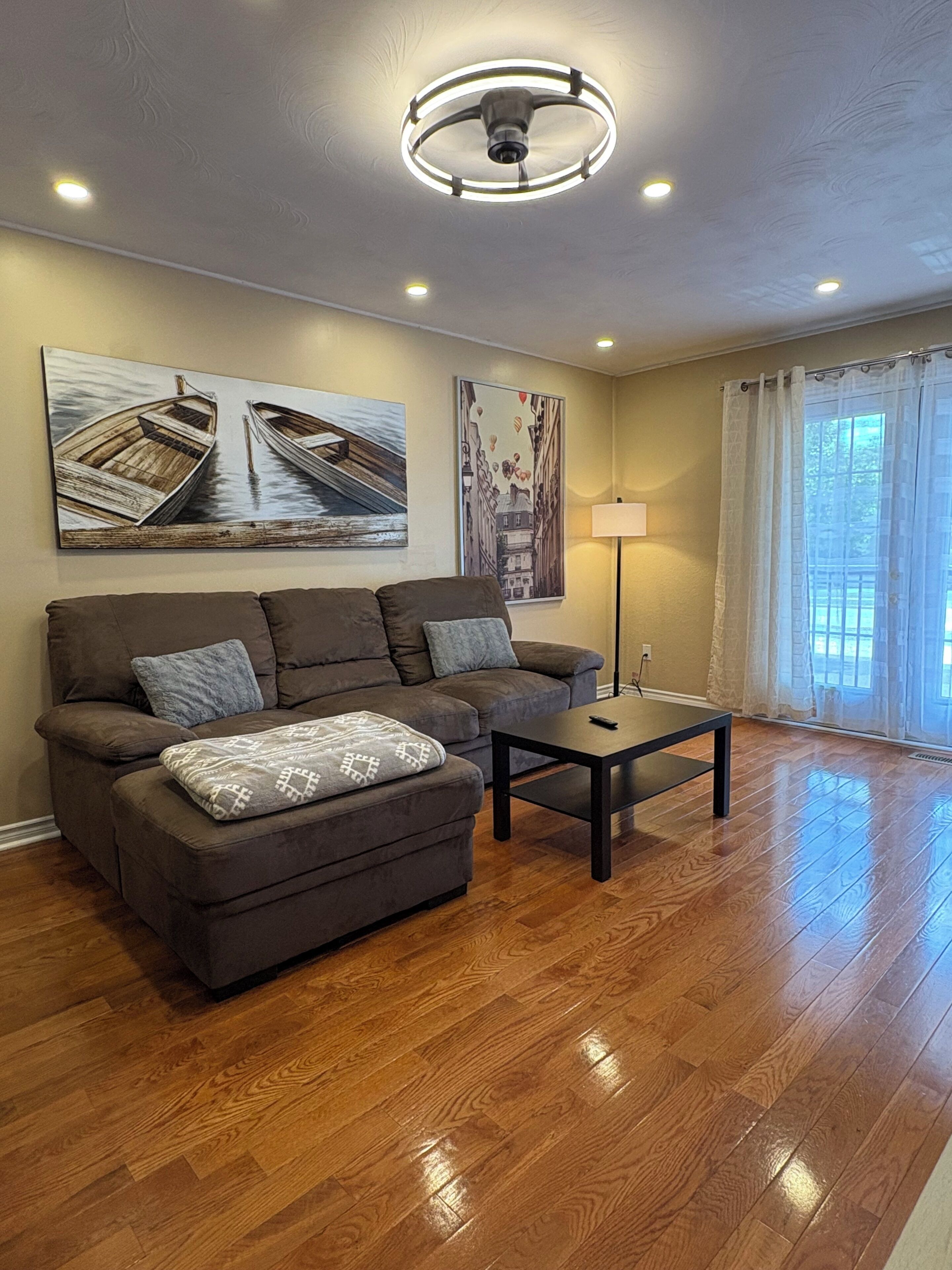 A living room with a sofa, a coffee table, and two wall-mounted paintings.