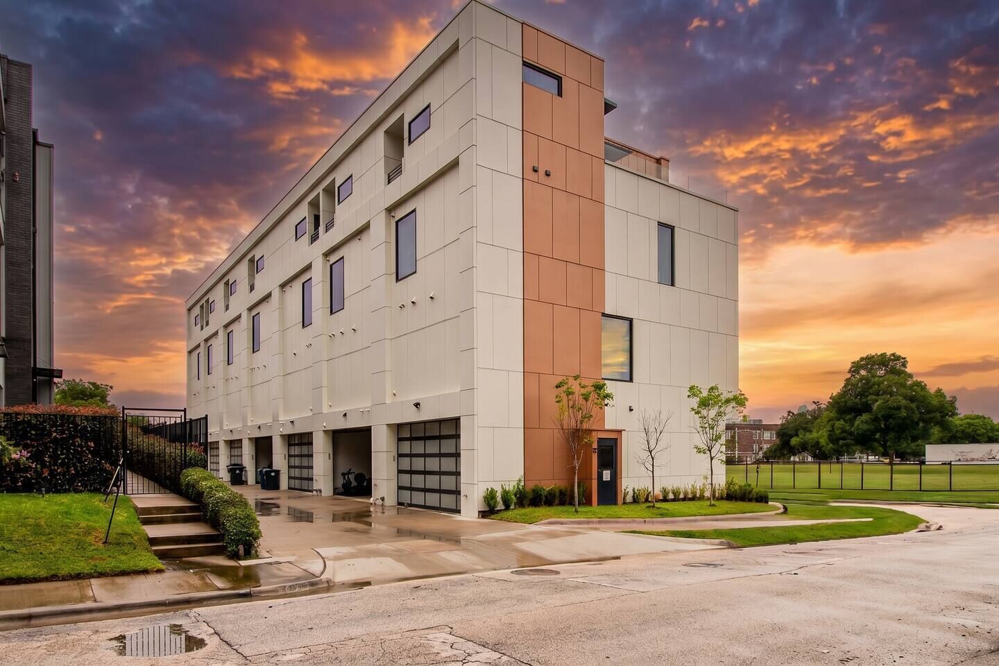 A multi-story building with a flat roof, large windows, and a parking garage.