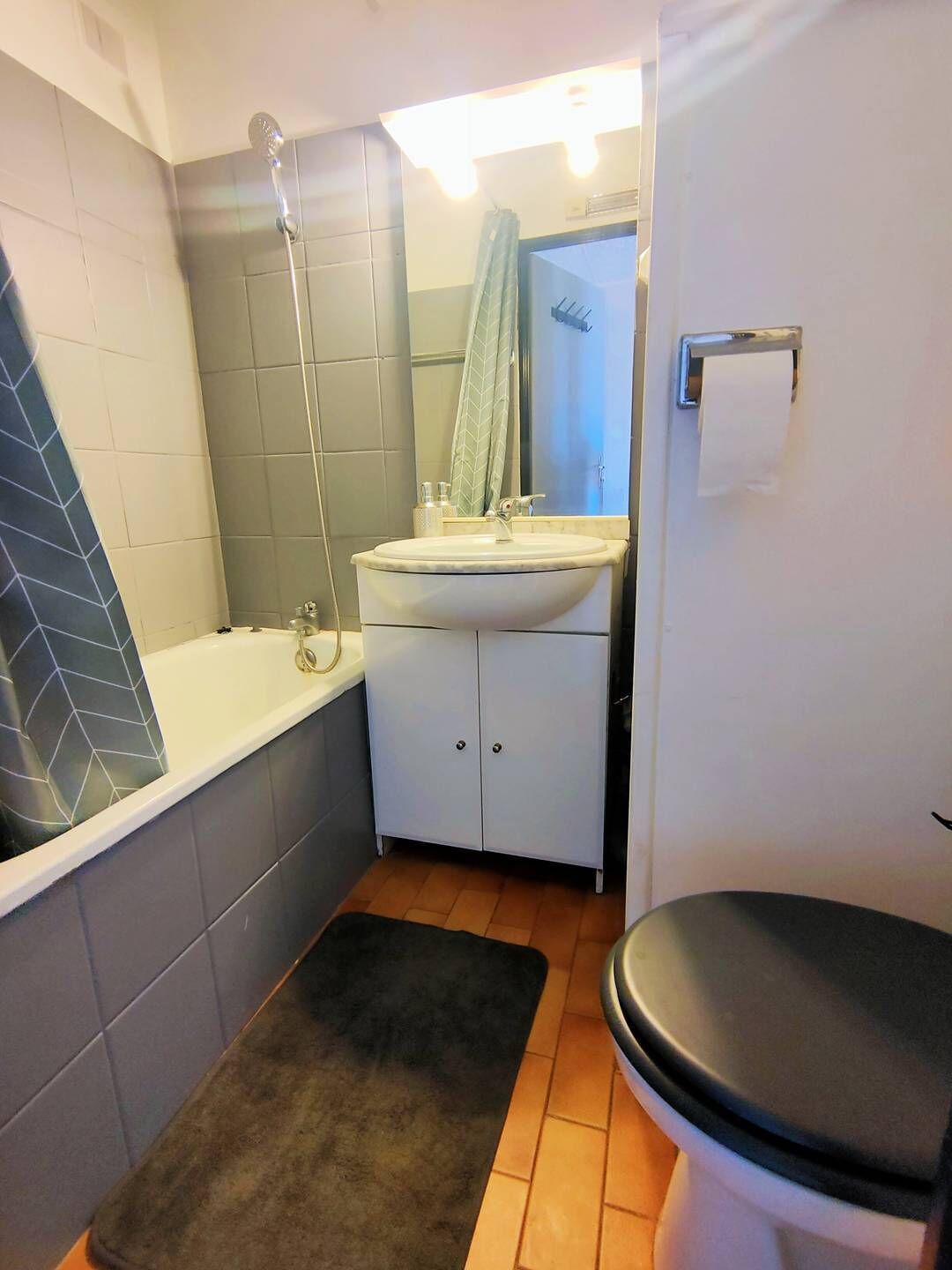 Een badkamer met een bad, wastafel, toilet en douche.