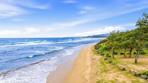 A beach with waves, a clear sky, and trees. - Oceanfront & Oceanview - Heated Pool - Fully Renovated - Walk to Lydgate Beach (Lihue)