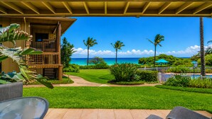 A covered outdoor area with a view of the ocean, a pool, and a building with a balcony. - Oceanfront & Oceanview - Heated Pool - Fully Renovated - Walk to Lydgate Beach (Lihue)